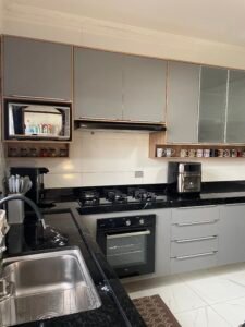 Cozinha na cor cinza sagrado e tamponamento com o teca soberano